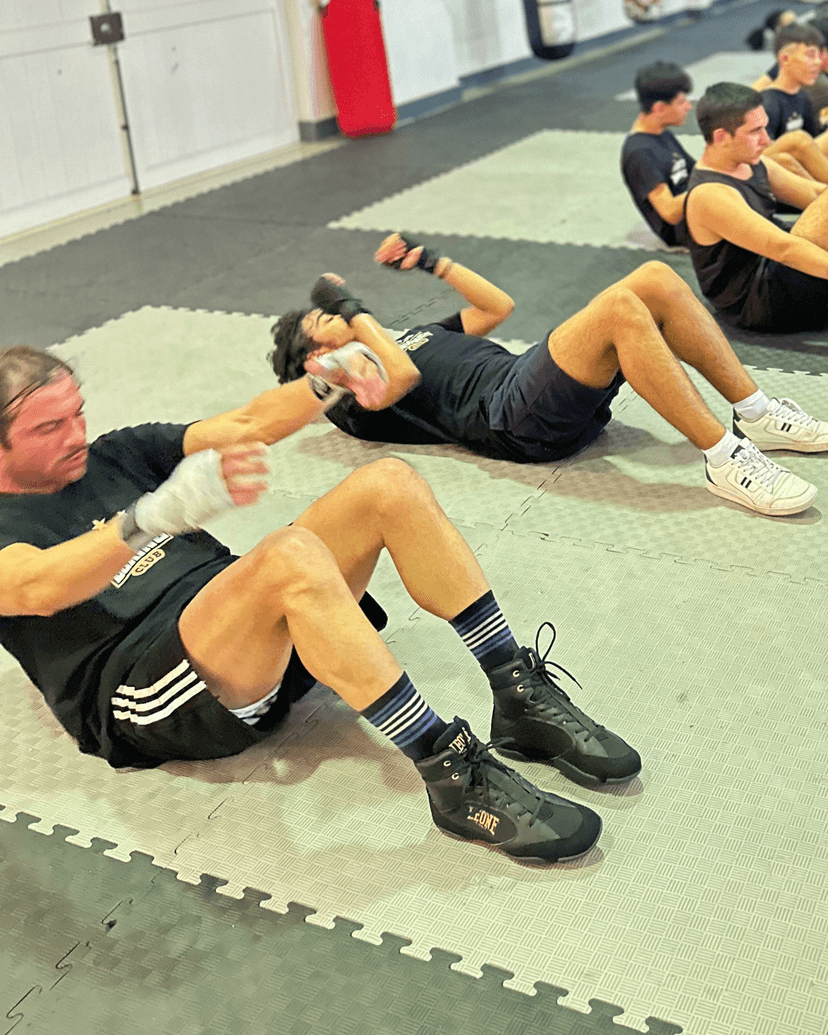 A person hitting a punching bag during a fitness class.